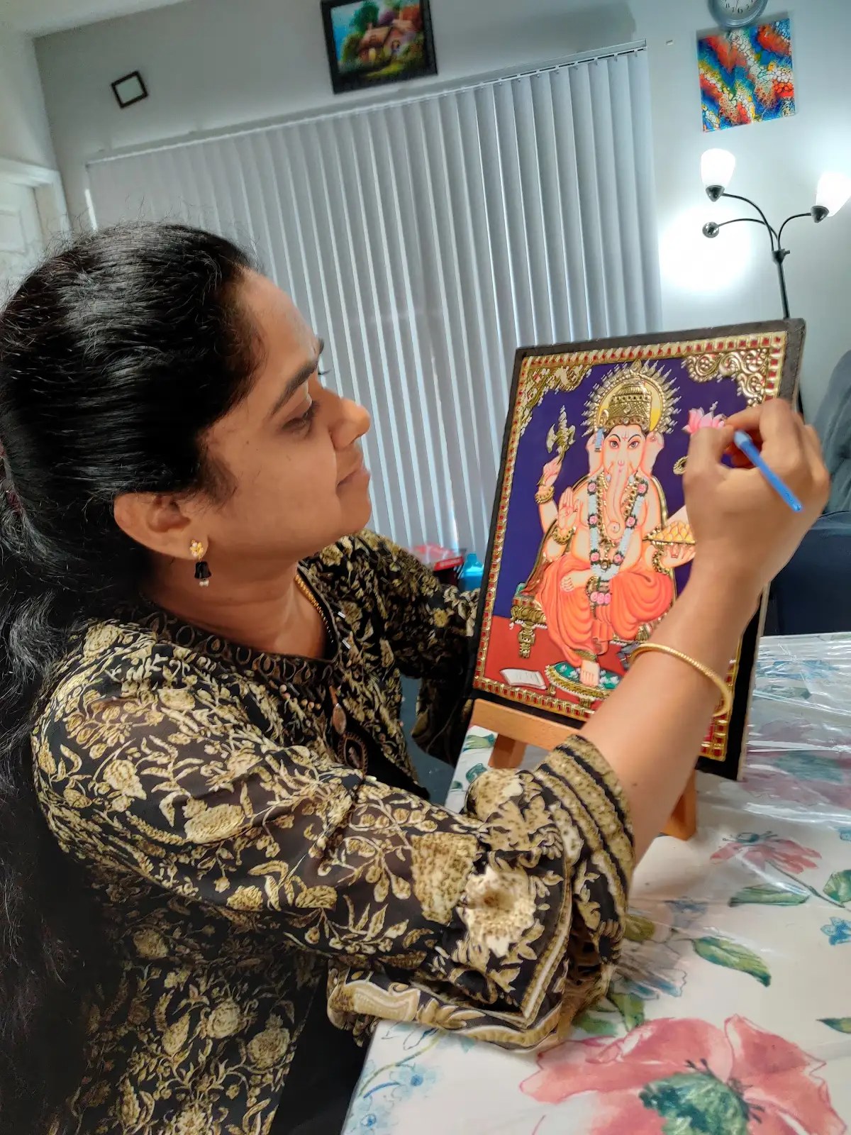 Ratnadevi Gogula painting a Tanjore-style Ganesh artwork