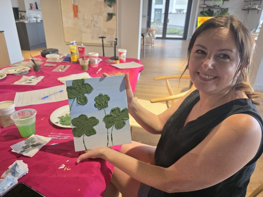 Art Club member holding her four-leaf clover painting at One Maidenhead