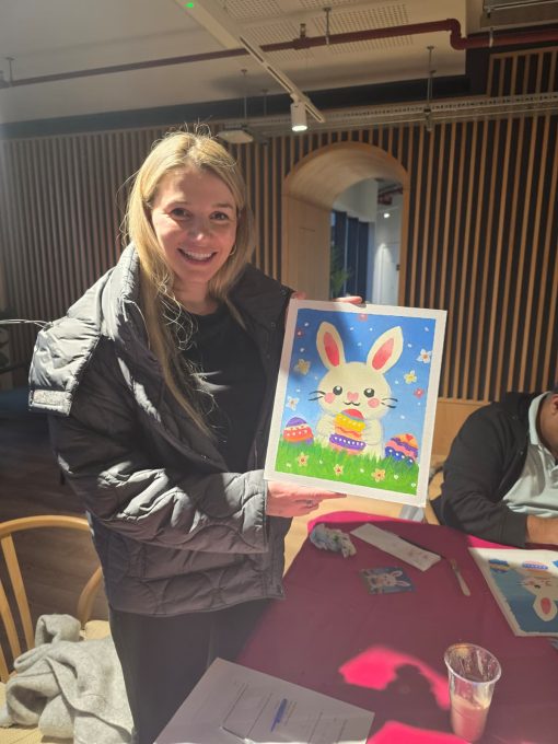 Art Club member holding a painted Easter bunny canvas