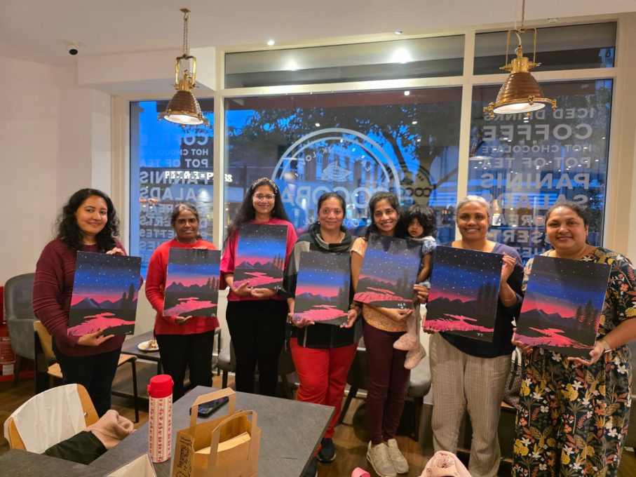 Art Club group holding up their finished twilight sky paintings