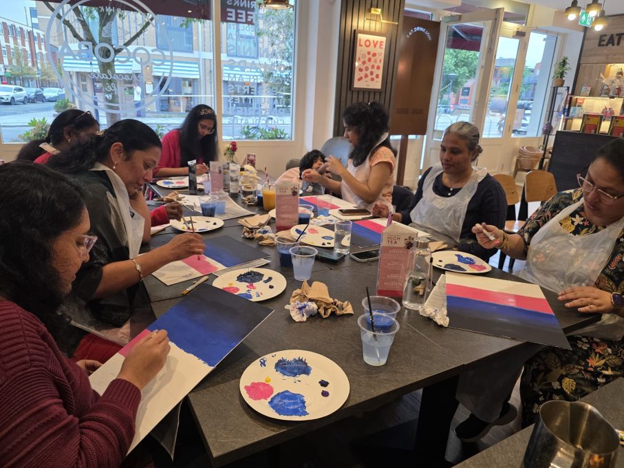 Art Club members painting together around the table