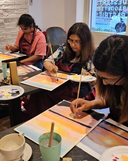 Art Club members painting sunset scenes