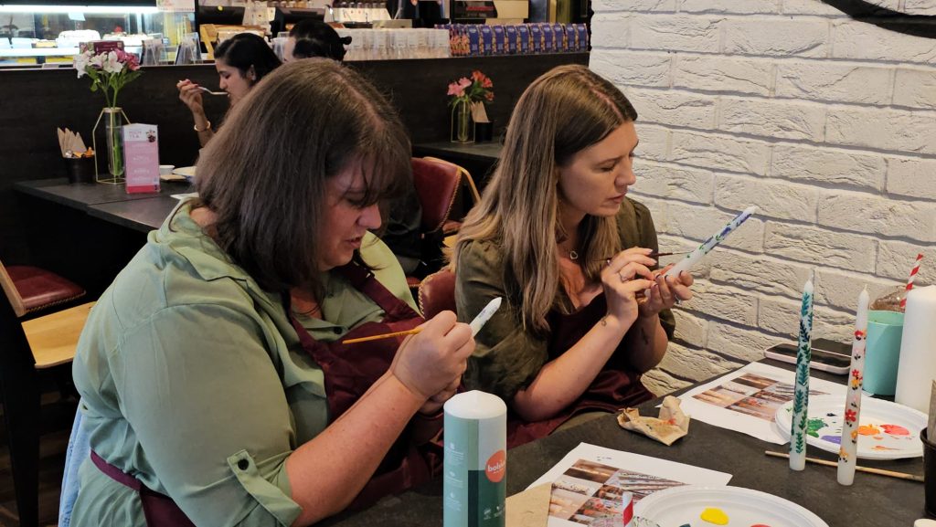 Two Art Club members painting together at a Devi Arts session