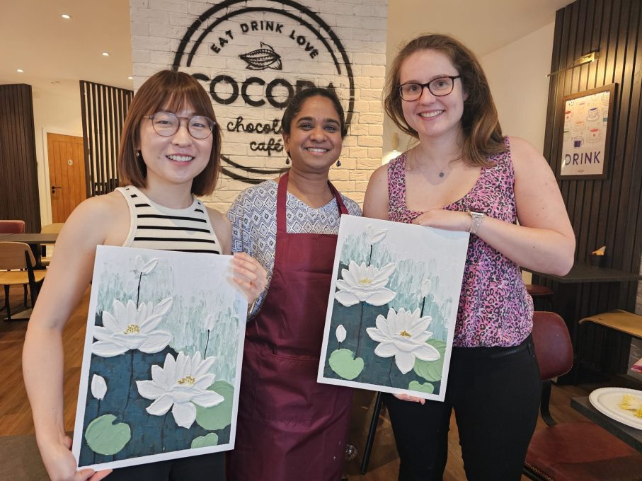 Art Club members proudly holding their finished water lily paintings
