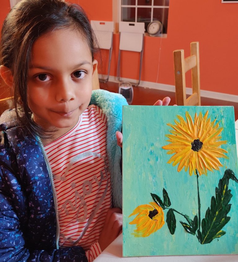 Young student with her finished sunflower painting
