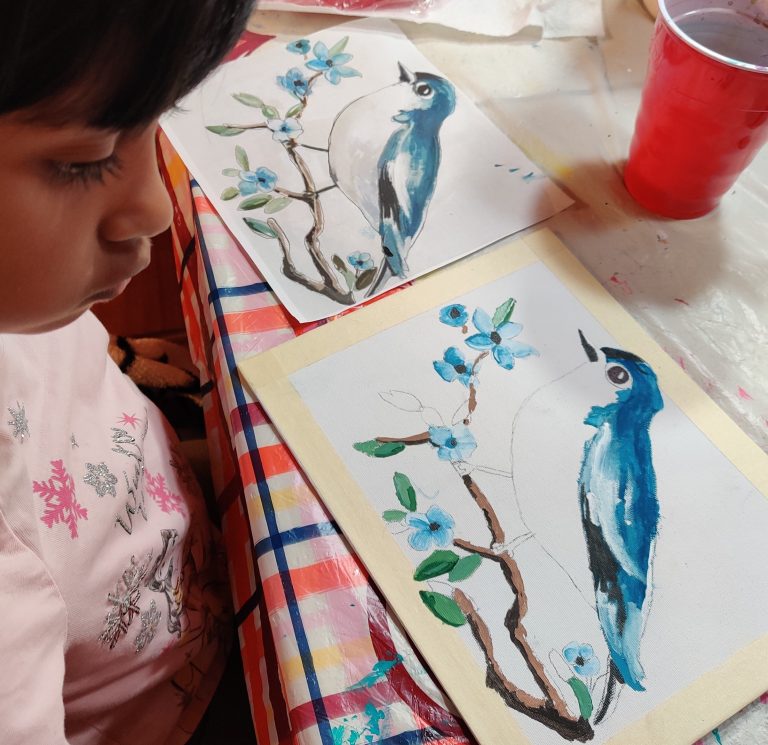 A young student working on a bluebird watercolour